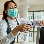 ppe thumbnail.jpg (Businesswoman with face mask disinfecting desktop PC...
