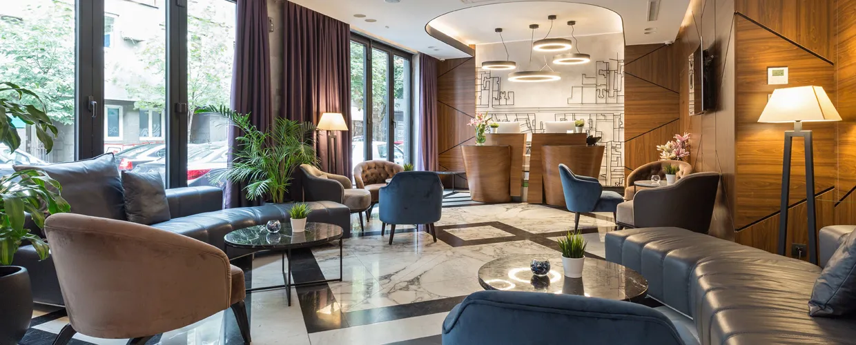 A modern hotel lobby with leather couches, beveled wood walls, and elegant lighting showcases the level of detail hotel operators need to provide a premium guest experience.